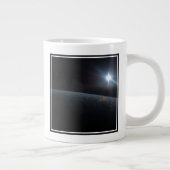 De zon gaat onder aan de horizon van de aarde. grote koffiekop (Rechts)