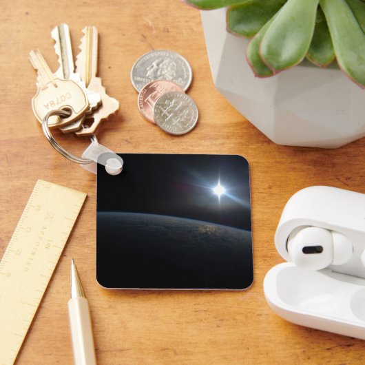 De zon gaat onder aan de horizon van de aarde. sleutelhanger (Bureau)