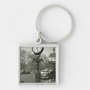 Decoratieve straatklok twee achtergrondmensen sleutelhanger