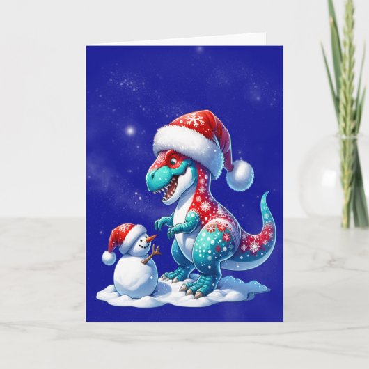 Dinosaur with santa hat building a snowman feestdagen kaart (Voorkant)