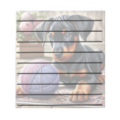 Doberman puppy met garenbal op een kleurrijk tapij notitieblok (Voorkant)