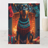 Dobermann-hond met kerstcadeaus bij de open haard kaart (Voorkant)