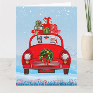 Dobermann in auto met kerstman kaart