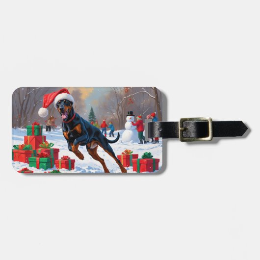 Dobermann loopt in de sneeuw met kerstmuts bagagelabel (Voorkant horizontaal)