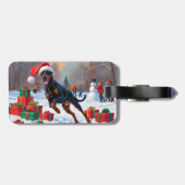 Dobermann loopt in de sneeuw met kerstmuts bagagelabel (Achterkant horizontaal)