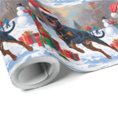 Dobermann loopt in de sneeuw met kerstmuts cadeaupapier (Rol Hoek)