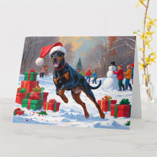 Dobermann loopt in de sneeuw met kerstmuts kaart