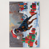 Dobermann loopt in de sneeuw met kerstmuts legpuzzel (Verticaal)