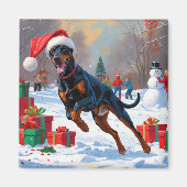 Dobermann loopt in de sneeuw met kerstmuts magneet (Voorkant)