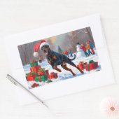 Dobermann loopt in de sneeuw met kerstmuts rechthoekige sticker (Envelop)