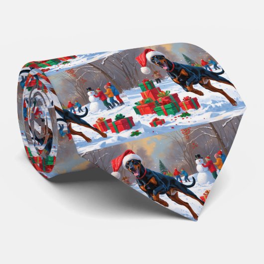 Dobermann loopt in de sneeuw met kerstmuts stropdas (Opgerold)