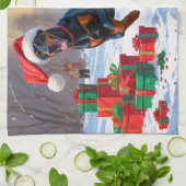Dobermann loopt in de sneeuw met kerstmuts theedoek (Gevouwen)