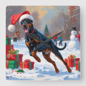 Dobermann loopt in de sneeuw met kerstmuts vierkante klok (Voorkant)