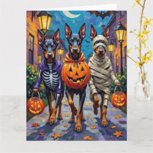 Dobermannenhonden gaan langs voor trick-or-treat o kaart
