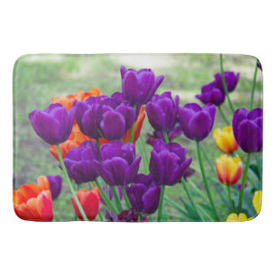 Donkere paarse tulpen op een zonnige dag in de tui badmat
