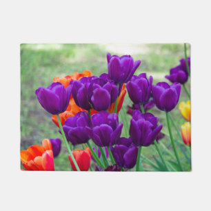 Donkere paarse tulpen op een zonnige dag in de tui deurmat