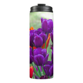 Donkere paarse tulpen op een zonnige dag in de tui thermosbeker