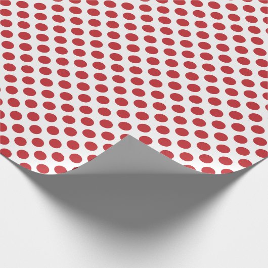 Donkere rode poladop op wit omslagpapier cadeaupapier (Hoek)