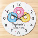 Donut Kitchen Gepersonaliseerd Grote Klok<br><div class="desc">Deze leuke klok is gedecoreerd met drie donuts in blauw, roze en geel op een sprinkhaan achtergrond. Eenvoudig aan te passen met jouw naam. Gebruik de optie Verdere wijzigingen aanpassen om de tekstgrootte, stijl of kleur te wijzigen als u dat wenst. Omdat we ons eigen kunstwerk creëer, zal je dit...</div>