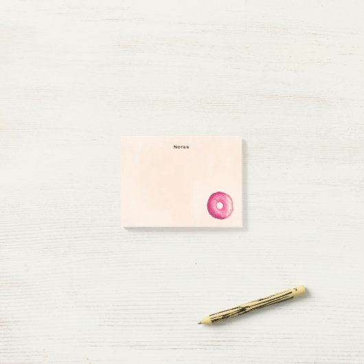 Donut met roze vorst en springen post-it® notes (Op bureau)
