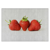Drie aardbeien op witte cbcnm snijplank (Voorkant)