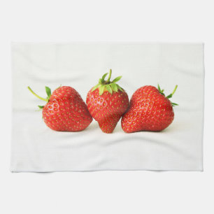 Drie aardbeien op witte kitcna theedoek