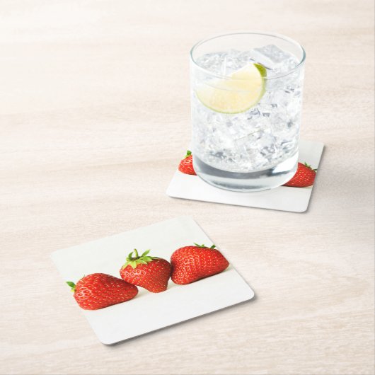 Drie aardbeien op witte kust kartonnen onderzetters (Insitu)