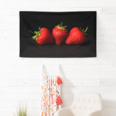 Drie aardbeien op zwarte brancna spandoek (Insitu)