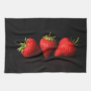 Drie aardbeien op zwarte ktm theedoek