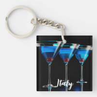 Drie blauwe cocktails met kersen op zwart