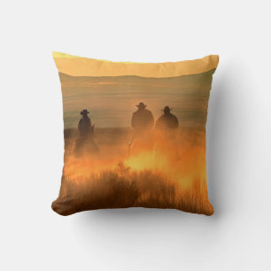 Drie cowboy galopperen op een achtergrond van de b kussen