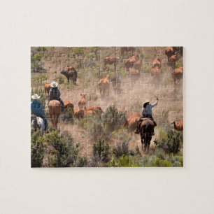 Drie cowboys en cowgirls die vee drijven legpuzzel