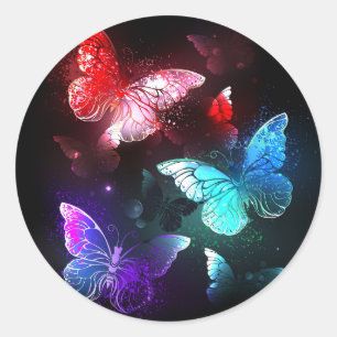 Drie gloeiende vlinders op een nachtachtergrond ronde sticker