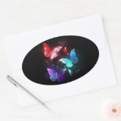 Drie gloeiende vlinders op nachtelijke achtergrond ovale sticker (Envelop)