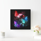 Drie gloeiende vlinders op nachtrustrondergrond vierkante klok (Huis)