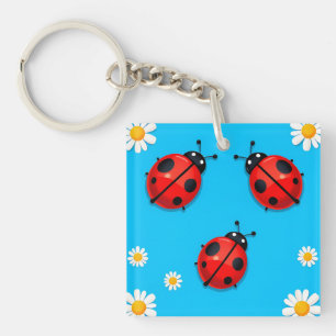 Drie kleurrijke lieveheersbeestjes op blauwe achte sleutelhanger