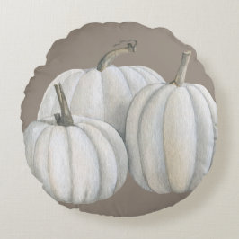 Drie witte pompoenen rond kussen