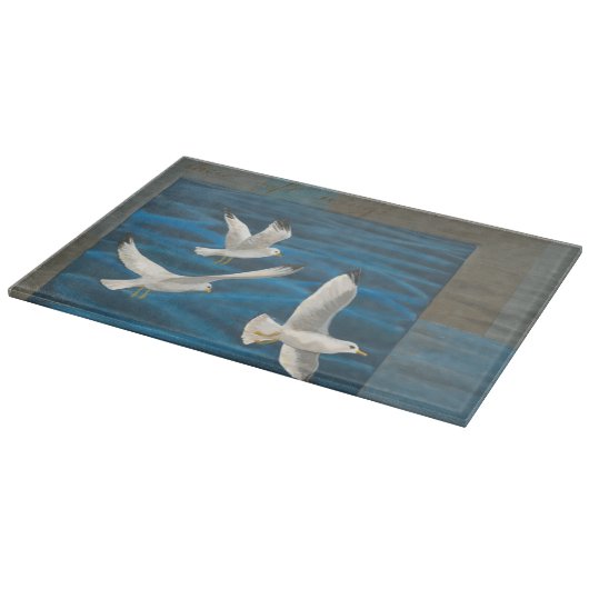 Drie witte zeegarren die over het water vliegen snijplank (Hoek)