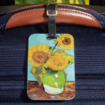 Drie zonnebloemen | Vincent van Gogh Bagagelabel<br><div class="desc">Three Sunflowers (1888) van Vincent van Gogh is een levendig stilleven dat de kenmerkende dikke penseelstreken en het gedurfde kleurgebruik van de kunstenaar laat zien. Het schilderij toont drie zonnebloemen in een eenvoudige vaas, hun gouden bloemblaadjes contrasteren tegen de aqua blauwe achtergrond. Van Goghs levendige gele palet brengt energie en...</div>