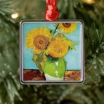 Drie zonnebloemen | Vincent van Gogh Metalen Ornament<br><div class="desc">Three Sunflowers (1888) van Vincent van Gogh is een levendig stilleven dat de kenmerkende dikke penseelstreken en het gedurfde kleurgebruik van de kunstenaar laat zien. Het schilderij toont drie zonnebloemen in een eenvoudige vaas, hun gouden bloemblaadjes contrasteren tegen de aqua blauwe achtergrond. Van Goghs levendige gele palet brengt energie en...</div>