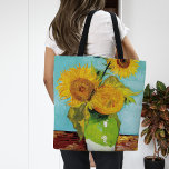 Drie zonnebloemen | Vincent van Gogh Tote Bag<br><div class="desc">Three Sunflowers (1888) van Vincent van Gogh is een levendig stilleven dat de kenmerkende dikke penseelstreken en het gedurfde kleurgebruik van de kunstenaar laat zien. Het schilderij toont drie zonnebloemen in een eenvoudige vaas, hun gouden bloemblaadjes contrasteren tegen de aqua blauwe achtergrond. Van Goghs levendige gele palet brengt energie en...</div>