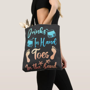 Drink in handspeelgoed in het zand - strand Gezegd Tote Bag