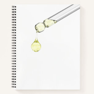 Druppelend geel serum uit een pipet notitieboek
