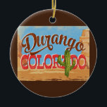 Durango Colorado Cartoon Desert Vintage Travel Keramisch Ornament<br><div class="desc">Durango Colorado neo vintage-reisontwerp in een grappige cartoon retro-stijl met de woestijn,  een cactus en rotsen. Blauw,  bruin en rood met groene cactus.</div>