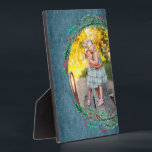 Easel foto van Wreater Tabletop Fotoplaat<br><div class="desc">Op een blauwe denimachtergrond is een poot aan pijnboomtakken, bessen en bladeren rond je favoriete foto op dit tafelblad geplaatst met een ingebouwde asel voor eenvoudig beeldscherm. Geweldig als geschenk of om je favoriete foto in je eigen huis weer te geven. Uw afbeelding kleuren worden direct op het hardboard paneel...</div>