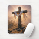 Easter Crosses On a Hill Muismat<br><div class="desc">A central wooden cross,  covered with a white cloth and illuminated by the warm glow of the setting sun,  stands out against two additional crosses on a rocky hillside in the background</div>