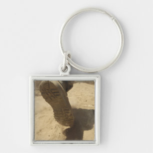 Een Amerikaanse soldaat loopt langs een vuile weg Sleutelhanger