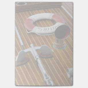 Een anker en een reddingsboei op een houten boot post-it® notes