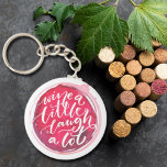 Een beetje lachen. sleutelhanger<br><div class="desc">De ronde knoop sleutelhanger kenmerkt de leuke tekst "Wijn a Little Laugh A Lot" op een rode wijnvlek. Sleutelhangers maken gedenkwaardige cadeaus voor familie en vrienden of voor jezelf creëer.</div>
