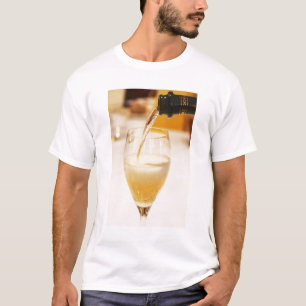 Een champagneglas fluit die wordt gevuld met Gosse T-shirt